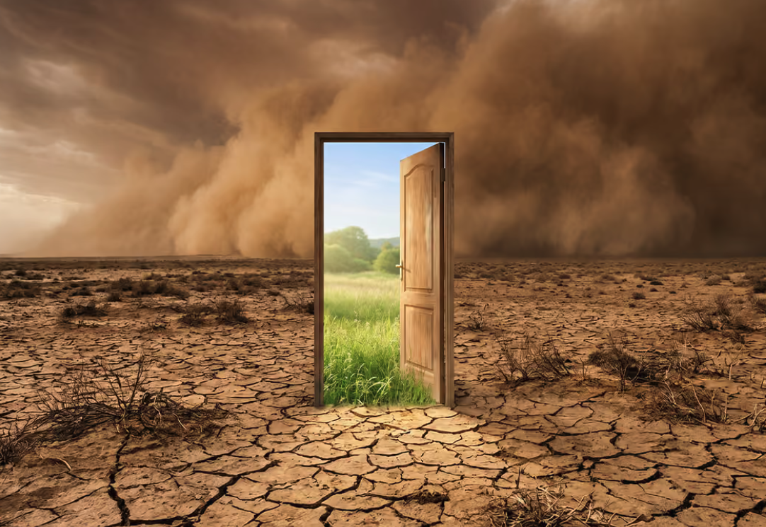Open door transitioning from cracked desert landscape to green grass, symbolizing access to healthcare and rural health solutions.